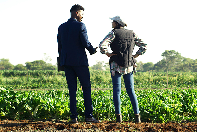 Female farmer speaking to a male business man in a suit